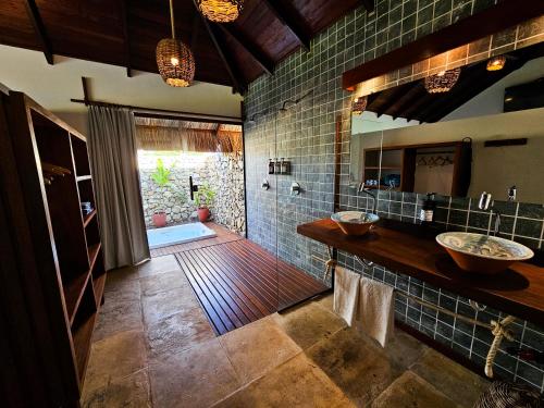 a bathroom with two sinks and a large mirror at Kauli Seadi Beach Hotel in São Miguel do Gostoso