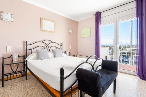 a bedroom with a large bed and a chair at Apartamento WELCS EMP-096- con vistas al canal in Empuriabrava