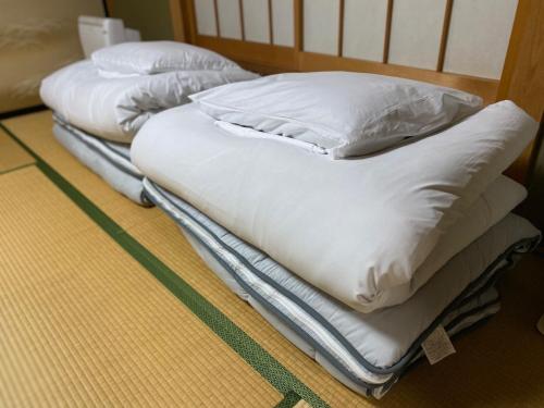 2 camas con almohadas blancas en el suelo en [Luxury villa with BBQ facilities overlooking Moun - Vacation STAY 14273, en Oishi