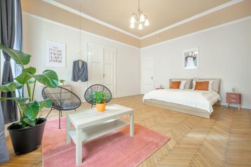 Dormitorio blanco con cama y mesa en Best Seasons Andrássy, en Budapest