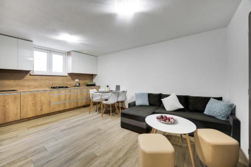 ein Wohnzimmer mit einem Sofa und einem Tisch sowie eine Küche in der Unterkunft Milan&Eva in Svätý Jur