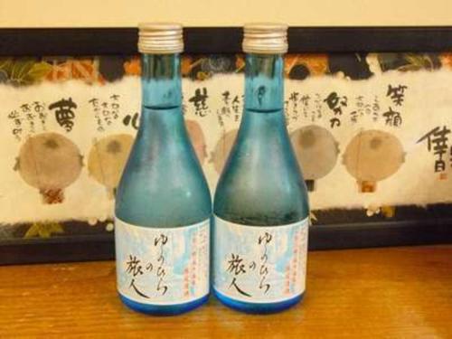 twee flessen wijn bovenop een tafel bij Ryokan Yamashiroya - Vacation STAY 21527v in Yufu