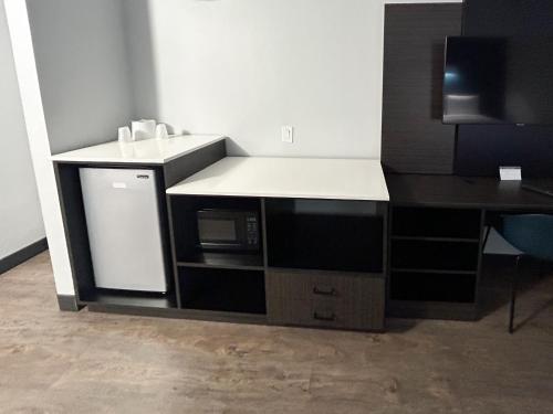 a kitchen with a counter with a sink and a microwave at Studio 6 Suites Carson, CA in Carson