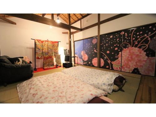a bedroom with a bed and paintings on the wall at Nishijin no Sato - Vacation STAY 54993v in Kyoto
