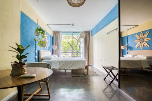a hotel room with two beds and a table at Selina Palermo in Buenos Aires