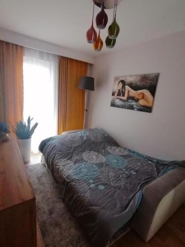 a bed in a bedroom with a picture on the wall at Apartament Euro 2 Kraków in Krakow