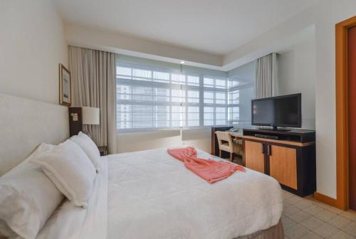 a bedroom with a white bed and a flat screen tv at Beautiful 1 Bedroom Brickell in Miami