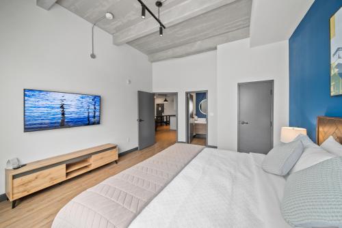 a bedroom with a white bed and a blue wall at Cannery Lofts Niagara in Niagara Falls