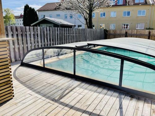 una piscina con un recinto de cristal en una terraza en Central villa med extra allt. Pool, Bastu, Utekök en Kalmar