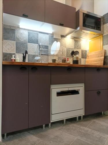 a kitchen with brown cabinets and a sink at le Travertin in Avignon