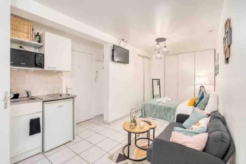 Il dispose d'une cuisine et d'un salon avec un canapé et une table. dans l'établissement Zenitude Studio au coeur de Lyon, à Lyon