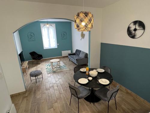 un salon avec une table et des chaises dans l'établissement Maison de ville à 2 pas de Rouen, à Bonsecours