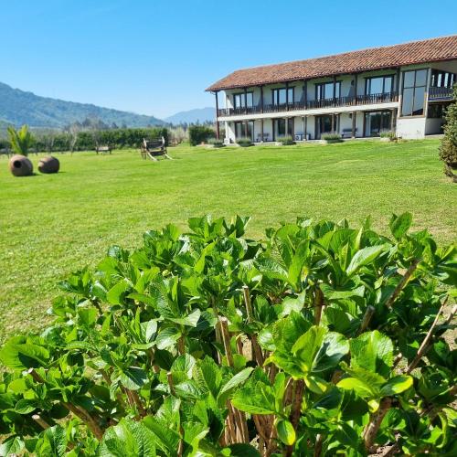 a building with a field of grass and a bush at Hotel Casa De Campo in Santa Cruz
