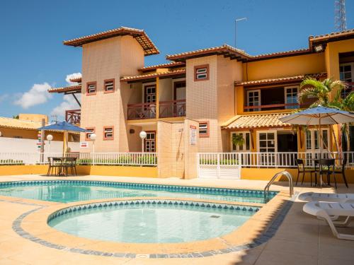 a swimming pool in front of a house at Pousada Mares em Sergipe in Estância
