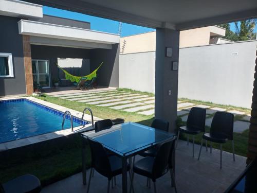 a patio with a table and chairs next to a swimming pool at VIDA NO PARAISO LAGOINHA in Lagoinha