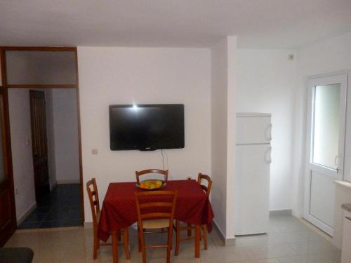 uma sala de jantar com uma mesa e uma televisão na parede em Apartment Mate em Korčula