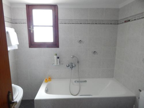a bathroom with a bath tub with a shower in it at Kaina Villa in Vamos