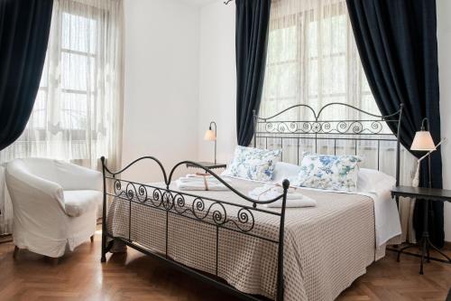 1 dormitorio con 1 cama, 1 silla y ventanas en Villa Belvedere - Località Barbiano, 3b, 50022 Greve in Chianti FI, Italy, en Greve in Chianti