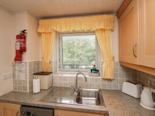 eine Küche mit einem Waschbecken und einem Fenster in der Unterkunft Apartment 3 in Keswick