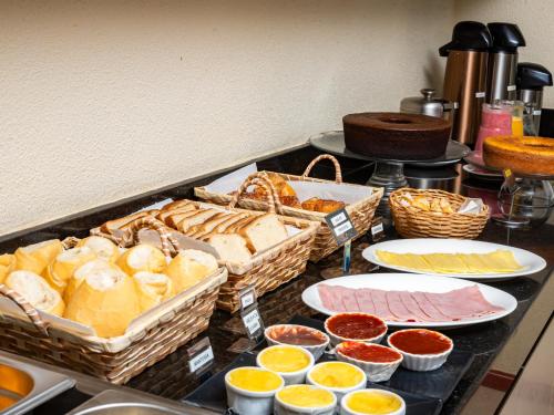 a buffet with bread and other foods on a counter at Pousada Mares em Sergipe in Estância