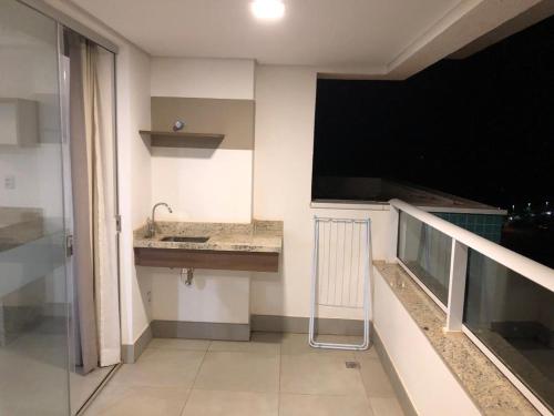 a small kitchen with a sink and a balcony at 2 DORMITÓRIOS FRENTE AO THERMAS DOS LARANJAIS in Olímpia