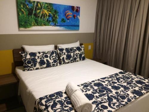 a bedroom with a bed with blue and white pillows at 2 DORMITÓRIOS FRENTE AO THERMAS DOS LARANJAIS in Olímpia