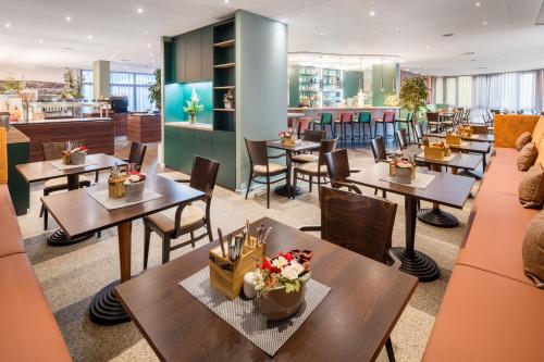 ein Restaurant mit Tischen und Stühlen und eine Cafeteria in der Unterkunft Best Western Hotel Wetzlar in Wetzlar