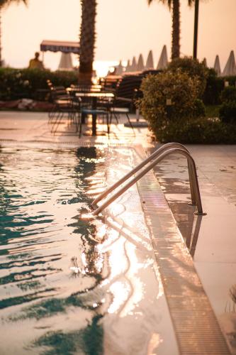 a swimming pool with a hand rail in a resort at Royal G Max in Golem