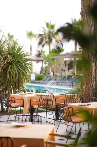 a row of tables and chairs next to a pool at Royal G Max in Golem