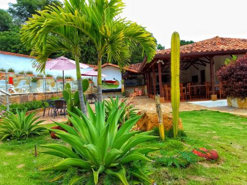 a house with a palm tree in the yard at Don Juan De Dios De Guane Hotel & Centro De Convenciones in Barichara