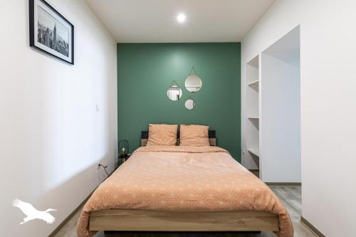 um quarto com uma cama com uma parede verde em Le BESSON BEY I - MEUBLEE DE STANDING T2 - Angoulême - Bord de Charente em Angoulême