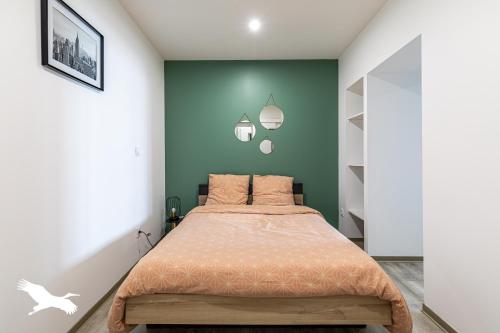 sypialnia z łóżkiem i zieloną ścianą w obiekcie Idéal couples & pro - Proche centre ville et gare - Promenade au bord de la Charente - Parking à proximité - Wifi très haut debit - Équipement premium -Netflix w mieście Angoulême