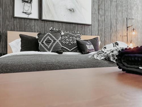 a bed with black and white pillows on it at Inn Santa Clara in Santa Clara