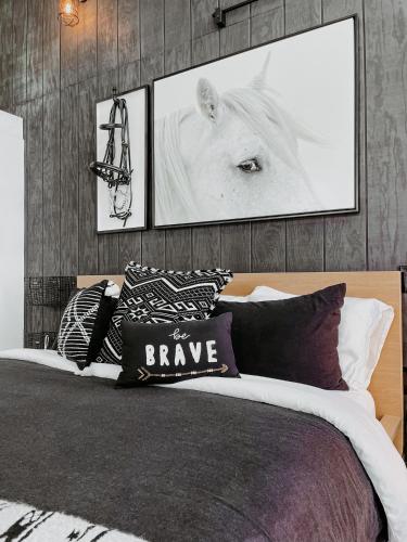 a bedroom with a bed with a white horse on the wall at Inn Santa Clara in Santa Clara