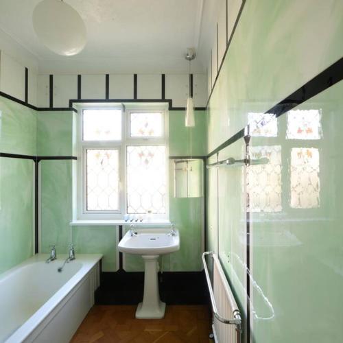 a bathroom with a sink and a tub and a window at Gorwel is an Art Deco 1930s villa with sea views in Deganwy