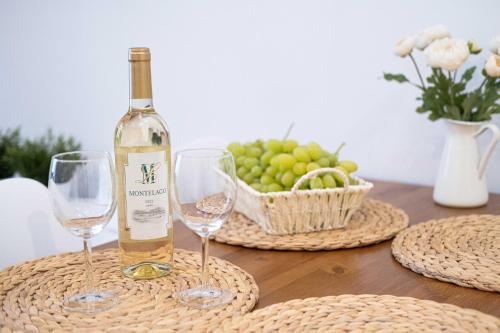 eine Flasche Wein und zwei Weingläser auf dem Tisch in der Unterkunft Old Town Zamkowa vis a vis Wawelu in Krakau