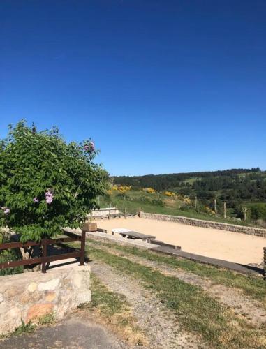 a park with a bench and a tennis court at Logement cocooning au cœur de la nature in Saint-Symphorien