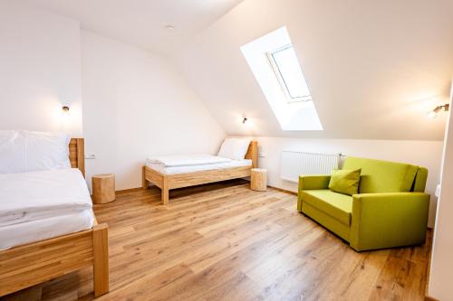a bedroom with a bed and a green chair at Wellness zoo apartmány Lhota in Lomnice nad Lužnicí