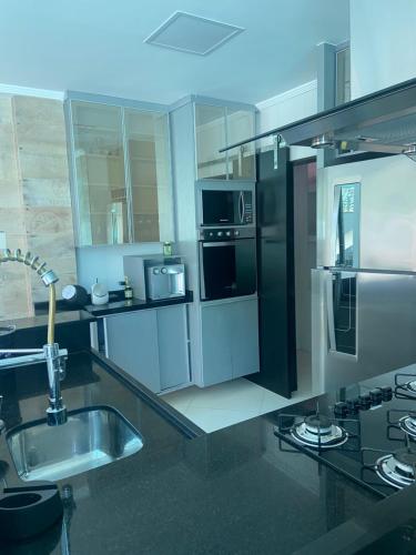 eine Küche mit Küchengeräten aus Edelstahl und einer Spüle in der Unterkunft Casa de praia mangaratiba in Mangaratiba