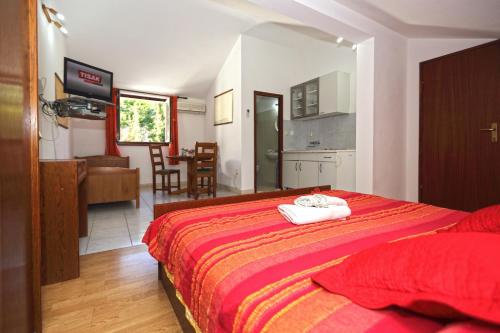 a bedroom with a bed and a kitchen and a dining room at Apartmani Katarina in Hvar