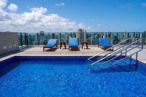 a swimming pool on the roof of a building at Roomo Praia de Boa Viagem Residencial in Recife