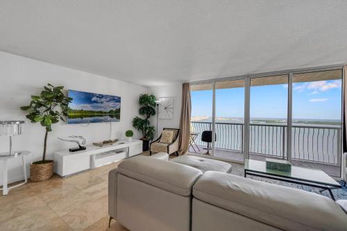 - un salon avec un canapé et de grandes fenêtres dans l'établissement *LUXURIOUS HIGHRISE 2BRCONDO BRICKELL- WATERVIEWS*, à Miami