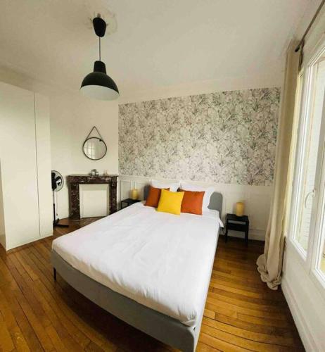 - une chambre avec un grand lit blanc et des oreillers jaunes dans l'établissement Bel appartement à Villemomble, à Villemomble