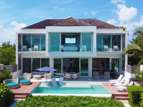 une villa avec une piscine et une maison dans l'établissement Long Bay Beach Club, à Long Bay Hills