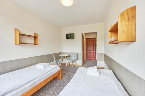 a room with two beds and a table at Ośrodek Wczasowy PANORAMA Szczyrk in Szczyrk