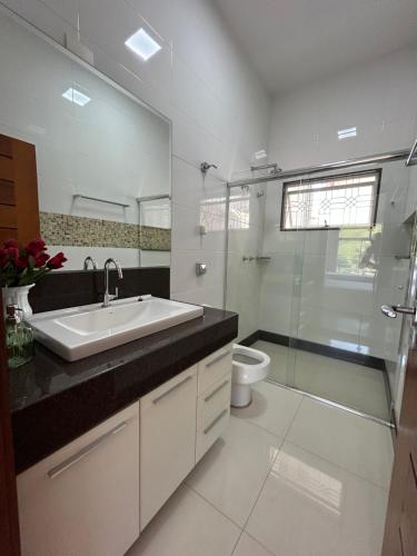 een badkamer met een wastafel, een toilet en een douche bij Suites Silva in Capitólio