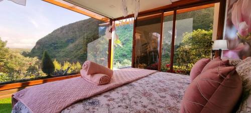 a bedroom with a bed with a view of a mountain at Termales Chachimbiro "Fuente de Vida" in Urcuquí