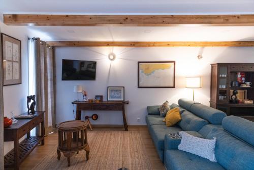 a living room with a blue couch and a table at 1884 Aveiro Loft in Aveiro