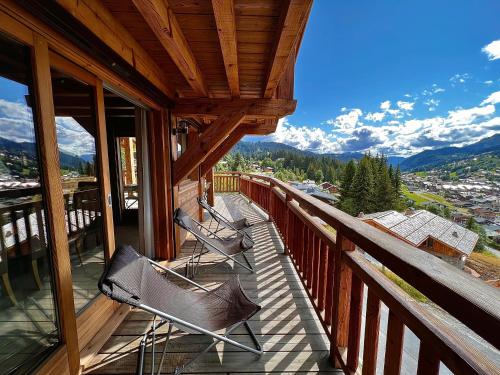 - deux chaises assises sur un balcon avec vue dans l'établissement Chalet les Gets, Vinson classé 5 étoiles, individuel avec jacuzzi privé, aux Gets