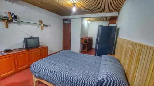 Schlafzimmer mit einem Bett und einem TV in der Unterkunft Loft con excelente ubicación en Valle de Bravo in Valle de Bravo